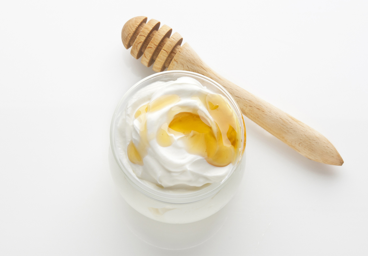 A bowl of yogurt and honey mixed for a DIY skin treatment